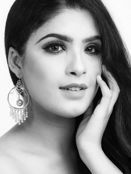 This black and white beauty portrait focuses on the model's face and statement jewelry. The clean composition and soft expression make it a sophisticated shot for a jewelry campaign or an editorial lookbook.