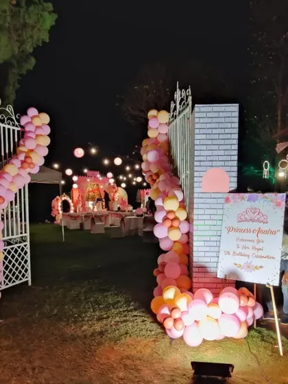 The castle gate entrance at night, illuminated by spotlights and the glow from the party within, creating a truly magical effect.