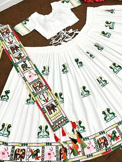 The complete white chaniya choli set laid out, showing the intricate embroidery on the skirt, the matching blouse, and the detailed dupatta. The tie-up back on the blouse ensures a comfortable fit.