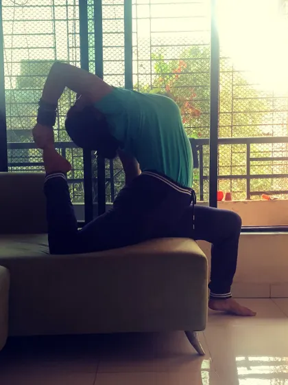 Opening up my heart chakra with a king pigeon pose on the sofa. You can practice yoga anywhere, using everyday objects to assist your stretches.