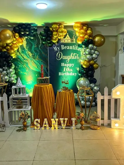 A grand setup for a 10th birthday party with a golden and blue balloon theme. The backdrop, props, and light-up numbers all come together to create a spectacular photo zone.
