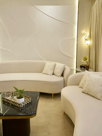 Another angle of the serene living space, showing how the two curved sofas create an intimate conversation area. The nesting coffee tables are both stylish and practical for small living rooms.