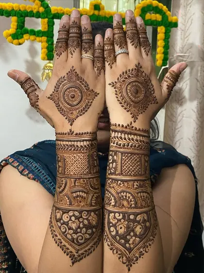 This design combines a mandala on the back of the hand with heavy, intricate bands on the arms for a full bridal look.