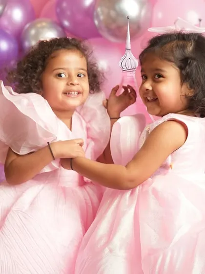 A sweet, interactive moment between two sisters during their fairytale photoshoot.