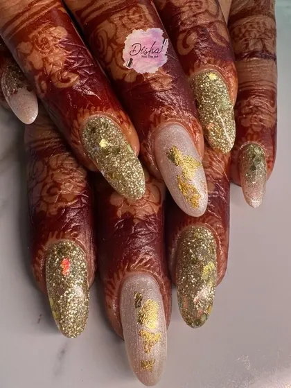 A stunning Karwachauth look. These glittery gold nails with foil accents look absolutely beautiful against the intricate henna design.