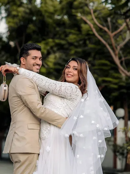 A joyful, candid shot of the bride and groom, with the bride wrapping her arms around her husband in a happy embrace.
