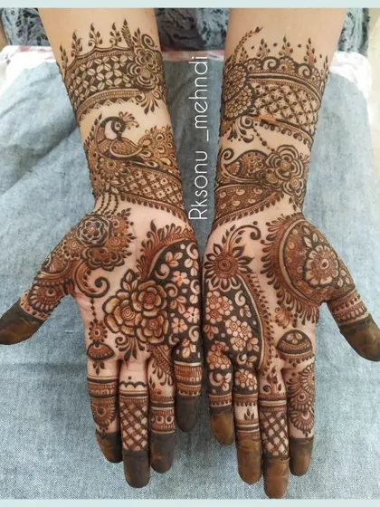 This half-hand designer mehndi is perfect for any occasion. It combines classic floral and peacock motifs with modern paisley and net patterns for a unique and elegant look.