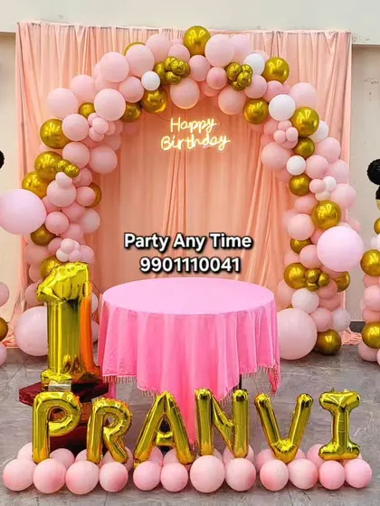 A classic Minnie Mouse theme for a first birthday. This setup includes a pink and gold balloon arch, Minnie Mouse balloon pillars, and large foil letters spelling out the name.