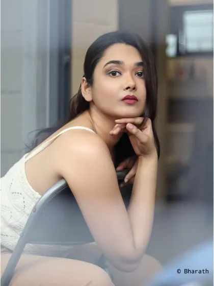A classic, thoughtful pose by a window, shot from outside to create a sense of looking in.