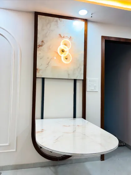 The finished folding table in its open position, featuring a beautiful marble-finish top. It is mounted within a decorative wooden frame that also houses an accent light.