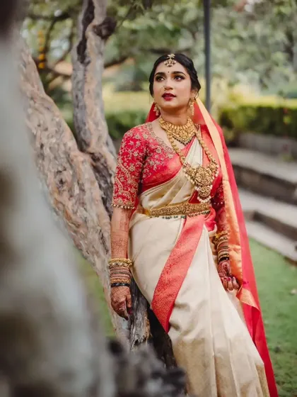 A moment of quiet contemplation for the bride. Her makeup features a classic red lip and defined eyes, a timeless choice for a South Indian wedding.