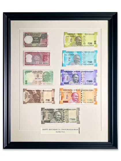 The complete framed collection of currency notes, featuring a custom-engraved caption for a birthday gift. This is a perfect example of how we can personalize frames for any special occasion.
