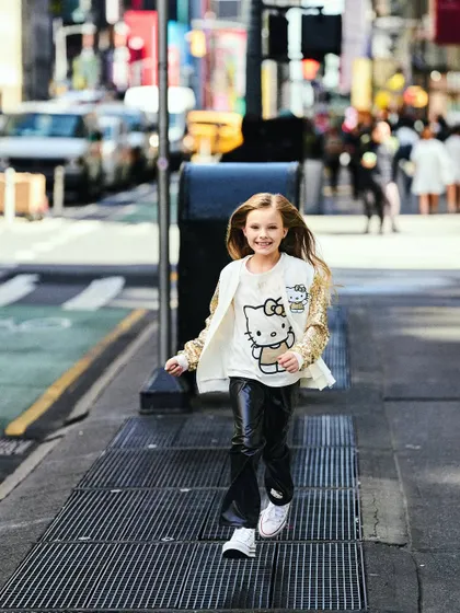 This shot captures the feeling of a girl taking on the city. The low angle and her confident stride make for a powerful and energetic image, with the NYC streets blurred in the background.