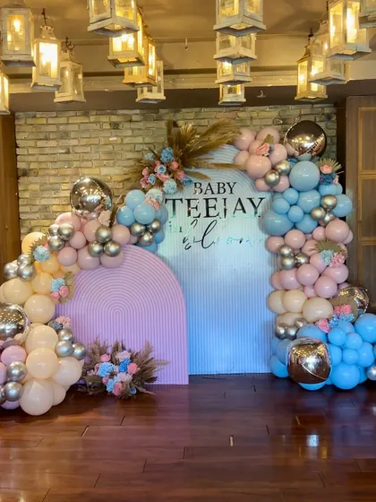 A beautiful pastel baby shower setup with pink and blue balloon arches, perfect for a gender reveal or a classic baby shower.