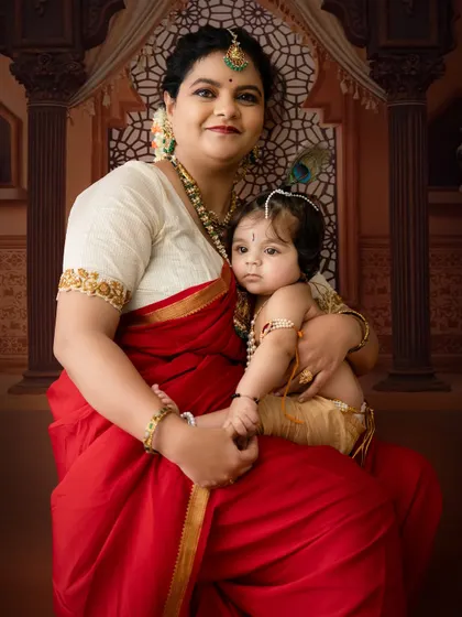 A tender moment between mother and child against a traditional Indian palace backdrop.