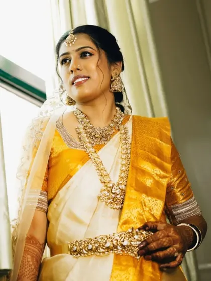 Natural light catching the bride's best features. This photo highlights the flawless skin finish and the intricate details of her temple jewellery, essential for a traditional wedding look.