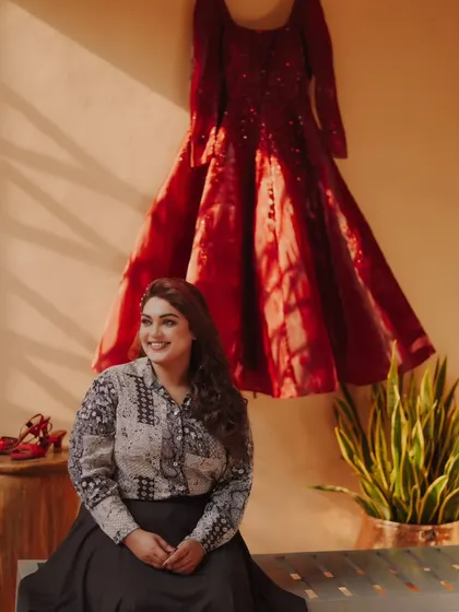 A creative "getting ready" shot, with the bride seated happily in front of her beautiful red gown.