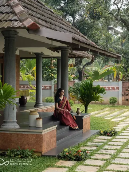 The expansive verandah with its polished stone pillars and traditional roof is a perfect example of climate-responsive design, offering a shaded space for relaxation.