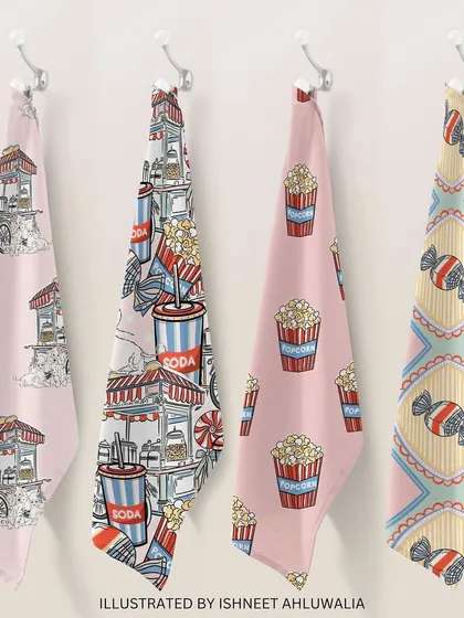 My 'Funfair Frenzy' patterns printed on kitchen towels. These playful designs, featuring popcorn carts and sweet treats, can bring a touch of fun and colour to everyday items.