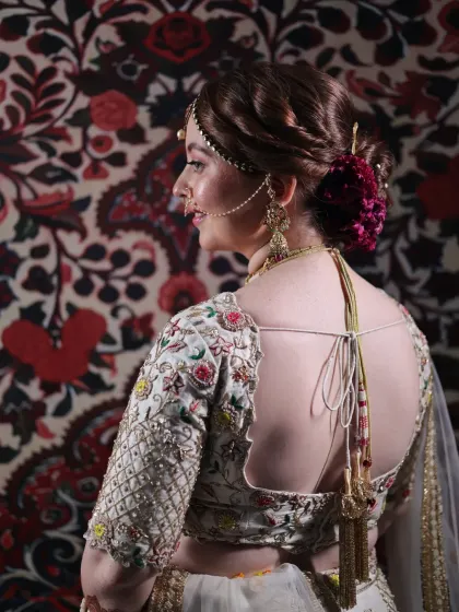 The back of the bridal look is just as important as the front. This view showcases the detailed embroidery of the blouse, the perfect draping of the dupatta, and the elegant floral bun.