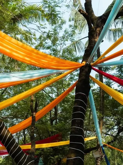 I used the natural landscape to our advantage, draping colorful fabrics from the trees to create a beautiful, flowing canopy over the event space.