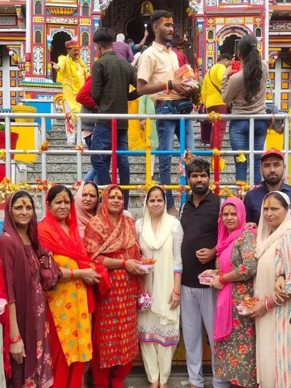 **A Group of Devotees at Badrinath.** A large group of women in colorful traditional attire, holding prasad after their darshan at the Badrinath temple.