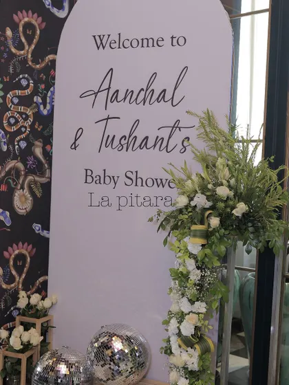 The welcome sign for the baby shower continued the modern, elegant theme. A clean white arch with minimalist typography was accented with a beautiful floral spray and disco balls for a touch of fun.