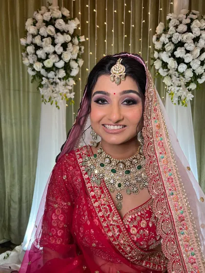 The complete look in front of the wedding decor. The makeup stands out beautifully, creating a focal point.