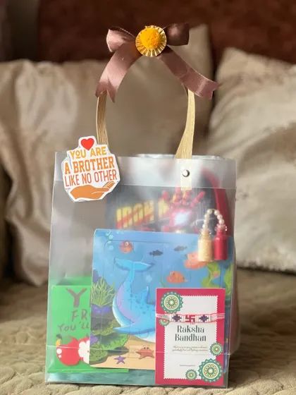 Another shot of the personalized Rakhi gift bag. The clear packaging lets the colorful gifts inside stand out.