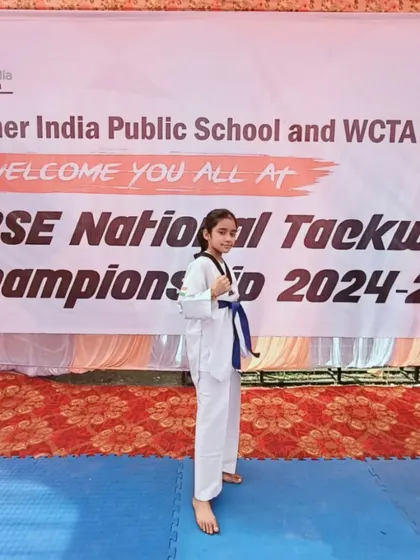 Naysha in her fighting stance in front of the CBSE National Championship banner. She is a true warrior.