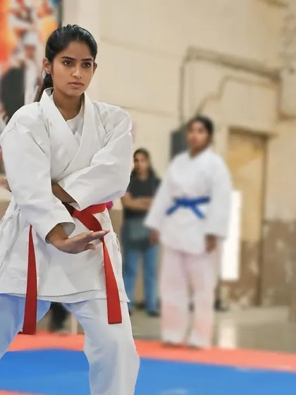 A focused gaze and a ready stance. This student is prepared to execute her kata with precision and power, embodying the spirit of karate.