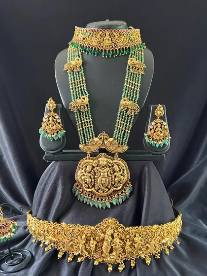 A full view of the green beaded antique set, showcasing the beautiful peacock motifs on the haaram and the detailed carvings on the vaddanam.