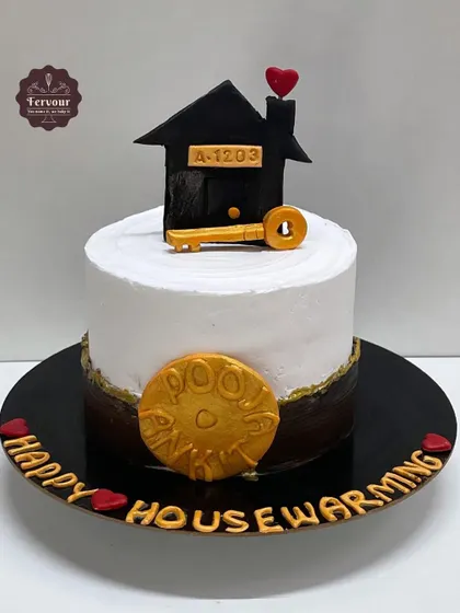 A housewarming cake to celebrate a new home. The design features a small house topper with the new address, a key, and a gold coin for good fortune.