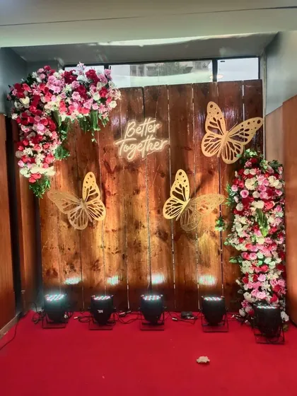 A popular selfie point design with a rustic wooden backdrop. It's adorned with floral arrangements and a "Better Together" neon sign, creating a perfect spot for guest photos.