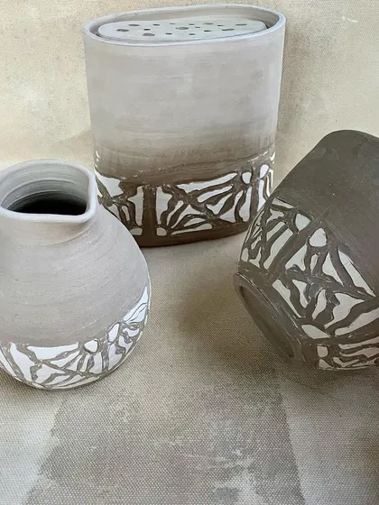 Another look at the elegant vases and cup with their delicate, nature-inspired patterns.