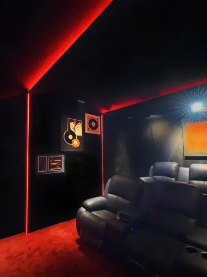 This angle of the home theater highlights the cool, retro-inspired wall decor featuring vinyl records, adding a personal and stylish touch to the entertainment space.