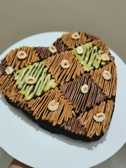 This assorted heart-shaped brownie is for those who love variety. It's sectioned and decorated with different toppings, including Nutella, pistachio, and Lotus Biscoff spreads, and sprinkled with hazelnuts.