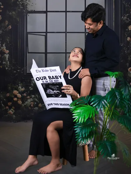 Another take on our popular "Baby Post" prop. This shot captures the couple's happy interaction and anticipation in a chic, dark-themed setting.