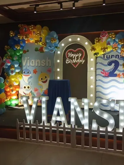 A fun-filled Baby Shark theme for a second birthday party. We created an underwater scene with character cutouts, large marquee letters for the name, and a lighted archway, making it a huge hit with the kids.