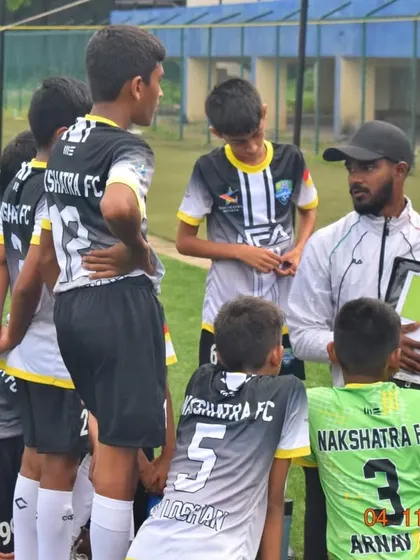 Strategy is key. Our coach uses a whiteboard on the field to explain formations and tactics to the U-13 team during a Karnataka Youth Premier League match.