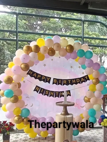 A pastel-colored balloon ring with a 'Happy Birthday' banner, perfect for a party with a view.