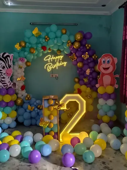 I can bring any theme to life, like this vibrant jungle-themed party for a second birthday. The setup includes a full balloon ring, large cutouts of jungle animals like a lion, zebra, and monkey, and a light-up marquee number.