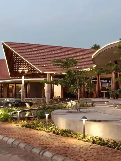 An evening view of the resort in Madurai during its construction phase. The design features flowing, organic lines and traditional tiled roofs, creating a modern yet culturally rooted hospitality space.