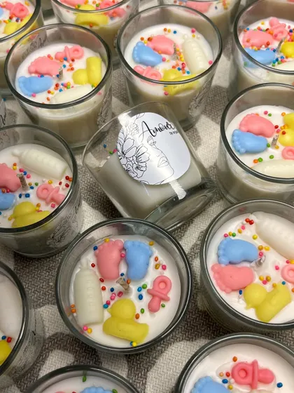 An overhead shot of the colorful and cute baby shower shot glass candles. The mix of pastel wax shapes and sprinkles creates a playful and celebratory vibe.