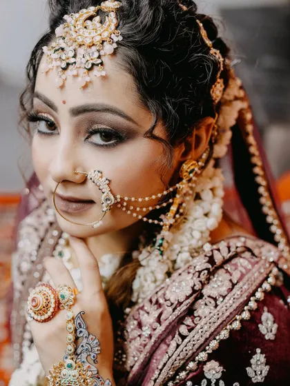A stunning close-up of a bride, showcasing her intricate nath and hand jewelry. We are experts at capturing the fine details of your bridal look.