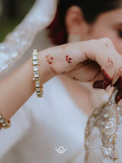 A close-up on the bride's hands and traditional bangles, a detail shot that speaks to tradition and style.