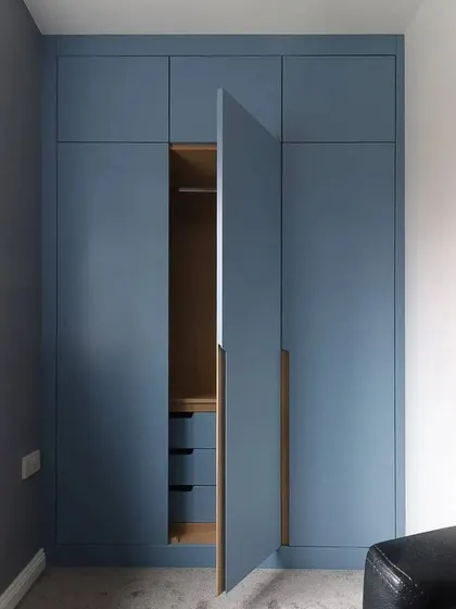 Another door of the blue wardrobe is open, revealing a section with drawers and hanging space.