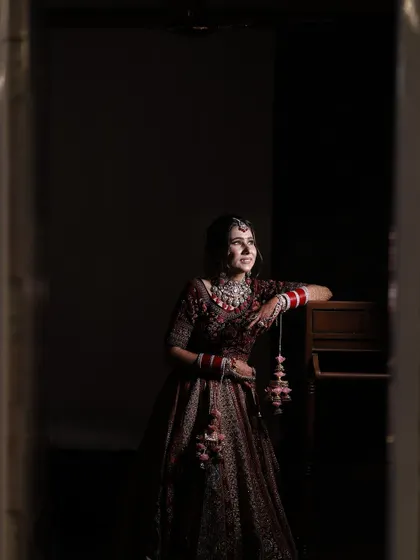A full-length shot capturing the grandeur of the bridal lehenga and the elegance of her overall look.