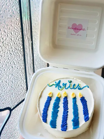 An Aries-themed bento cake with blue ombre candles. We can create custom designs for any zodiac sign to celebrate your season.