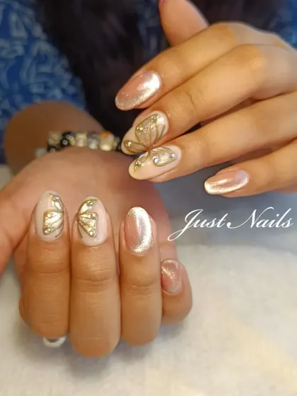 A delicate and whimsical design featuring a shimmery nude base with hand-painted gold butterfly wings and rhinestone accents.
